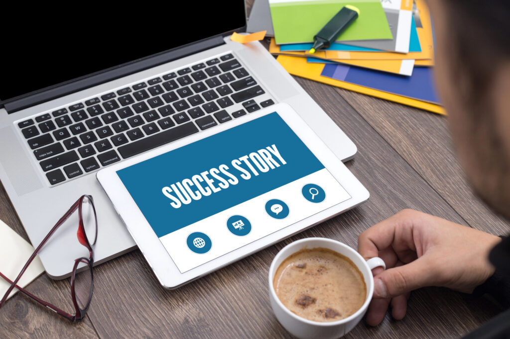 Tablette affichant "Success Story" sur un bureau de travail