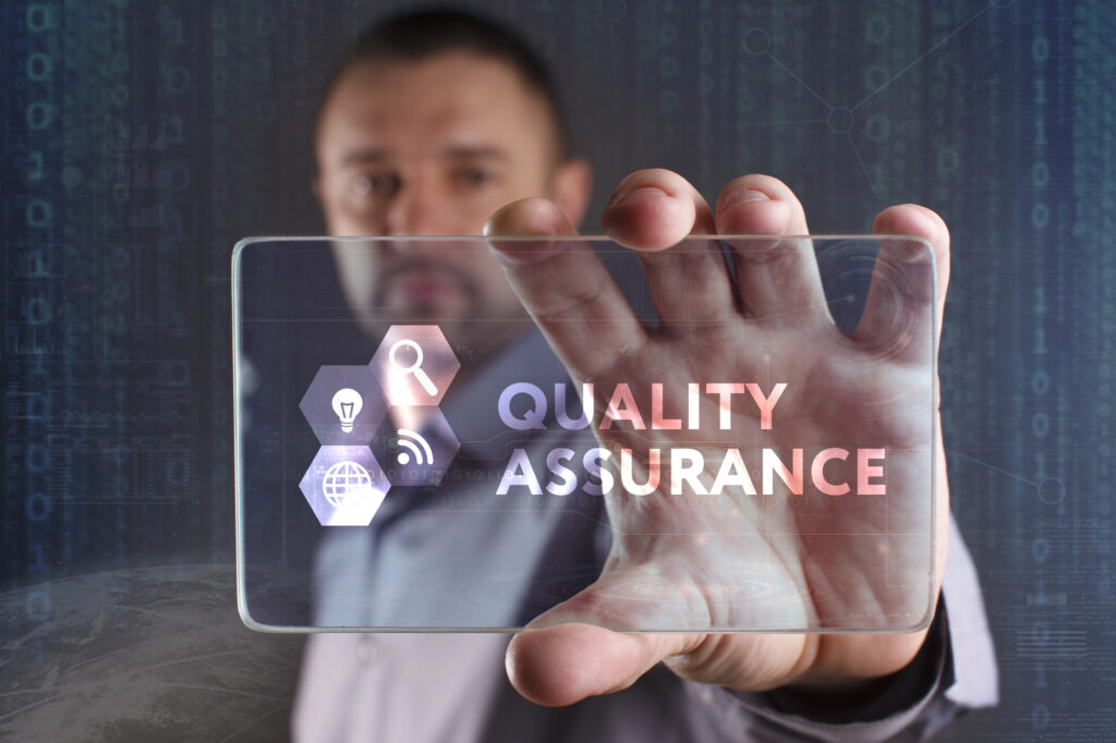 Main tenant une plaque de verre "Quality Assurance"