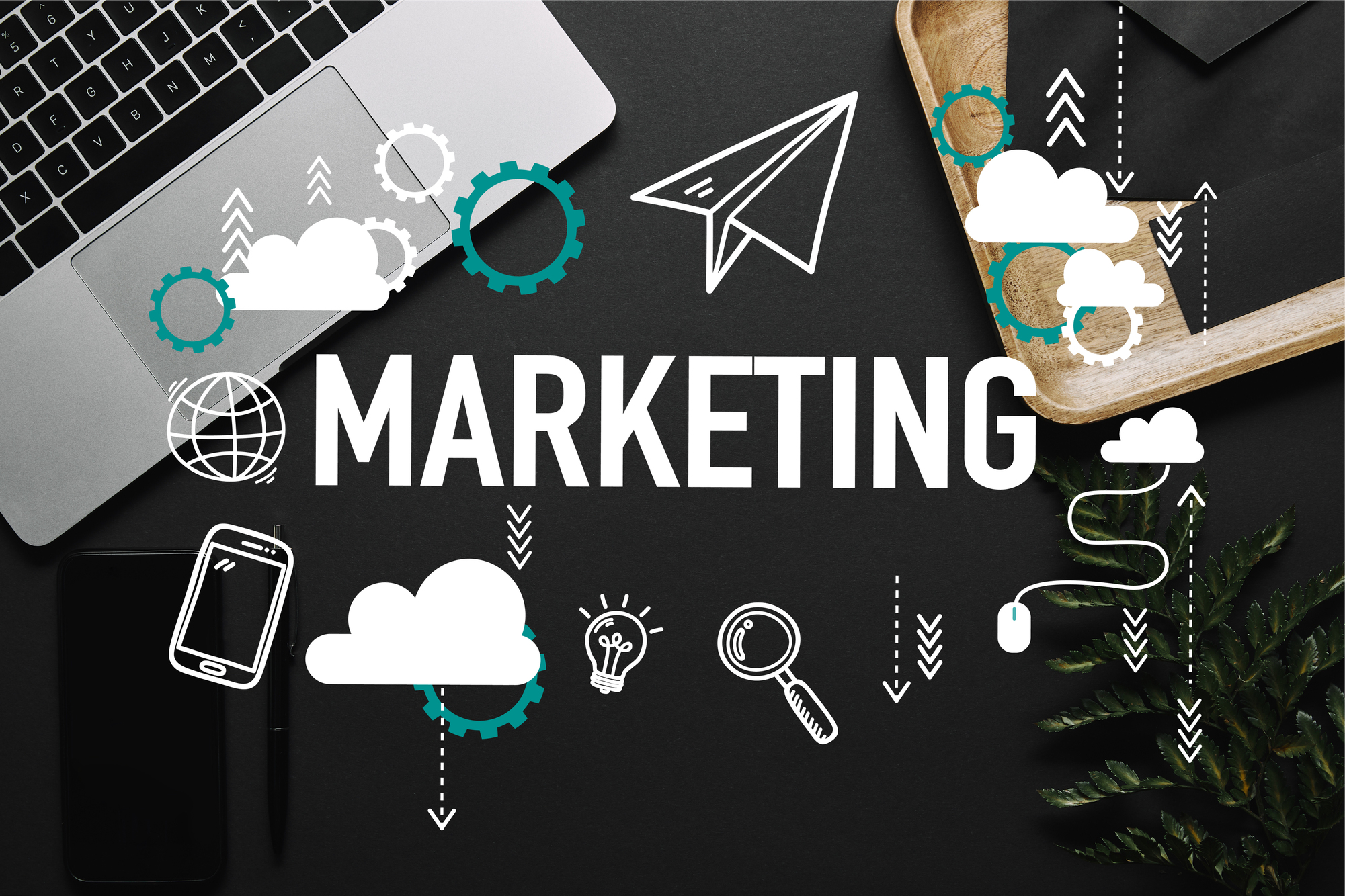 Mot « MARKETING » entouré d'icônes digitales sur un bureau