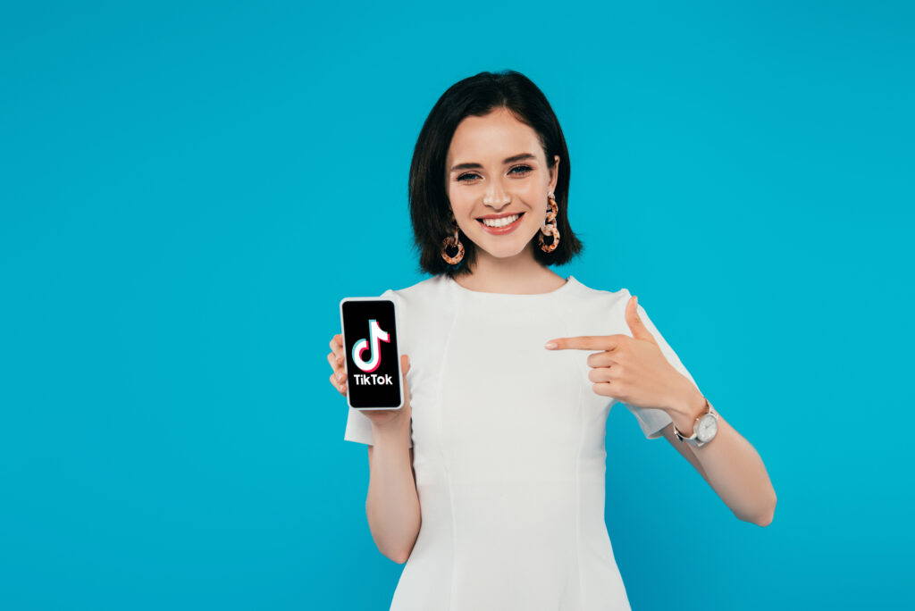 Jeune femme pointant un smartphone avec le logo TikTok