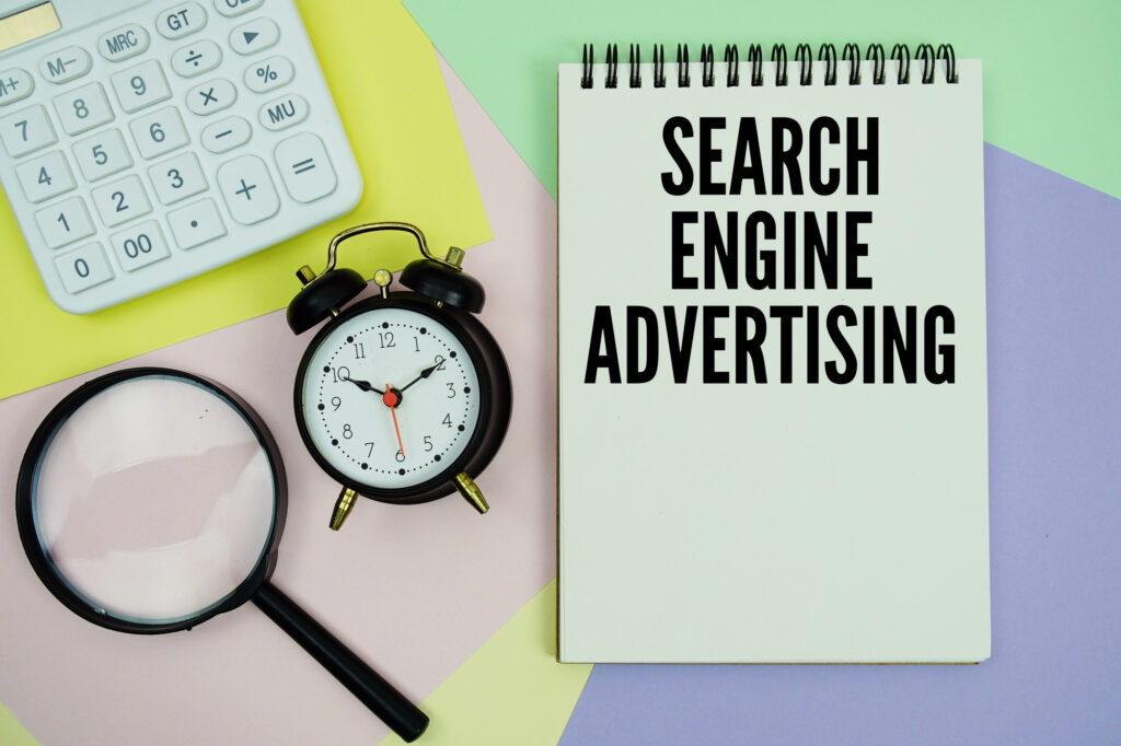 Carnet avec l'inscription Search Engine Advertising et une loupe