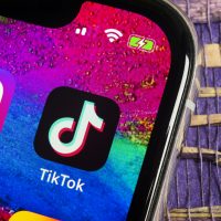 L'écran du smartphone affiche l'icône TikTok