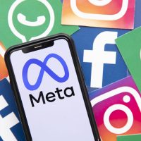 Un smartphone affichant le logo Meta entouré d'icônes de réseaux sociaux.