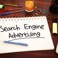 Bloc-notes avec l'inscription Search Engine Advertising sur un bureau