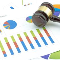 Marteau de juge posé sur des graphiques de ventes