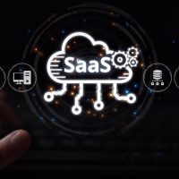 Logo SaaS lumineux survolant des mains utilisant un clavier.