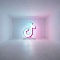 logo tiktok néon lumineux dans une grande pièce blanche vide.